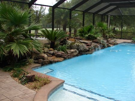 Pool Enclosure with Rock Landscape and Waterfall